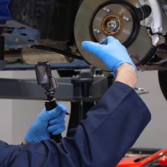 A workshop technician showing brake-pad wear via CitNOW