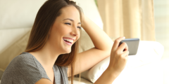 Woman looking at her mobile phone laughing
